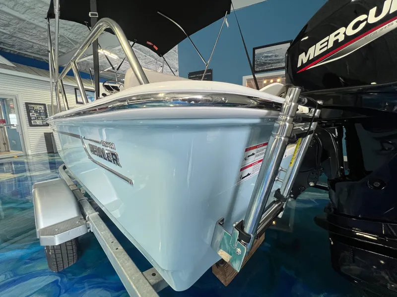 Slide: The Image of 2026 Boston Whaler 150 Montauk boat with Mercury engine in showroom. - 30