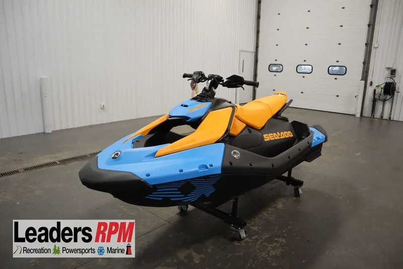 The Image of 2026 Sea-Doo Spark Trixx for 3 in vibrant blue and orange, displayed indoors. - 2