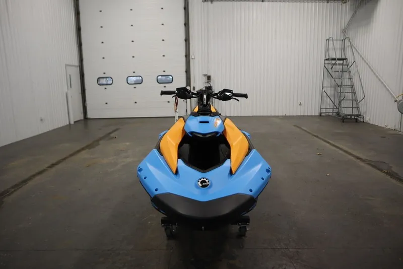Slide: The Image of 2026 Sea-Doo Spark Trixx for 3 in a garage, showcasing vibrant blue and orange design. - 3