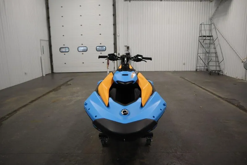Slide: The Image of 2026 Sea-Doo Spark Trixx for 3 in a garage, showcasing vibrant blue and orange design. - 3