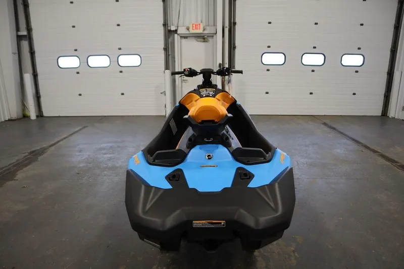 Slide: The Image of 2026 Sea-Doo Spark Trixx for 3 in a garage, showcasing vibrant blue and orange design. - 8
