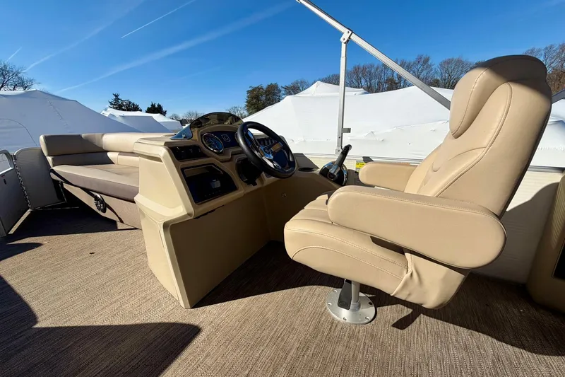 Slide: The Image of 2023 Godfrey Sweetwater 2286 SFL boat interior with beige captain's chair and dashboard. - 11
