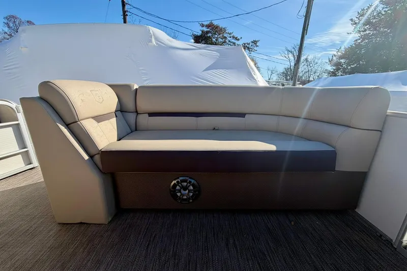 Slide: The Image of 2023 Godfrey Sweetwater 2286 SFL boat interior with beige seating and speaker. - 12