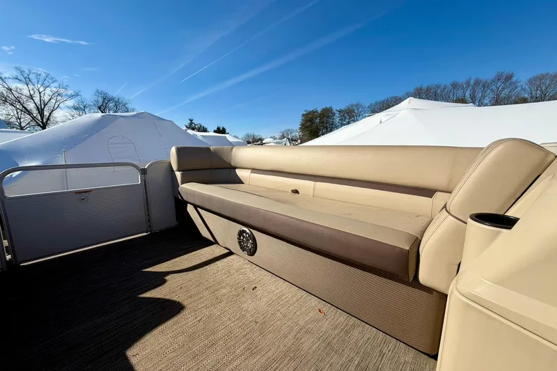 Slide: The Image of 2023 Godfrey Sweetwater 2286 SFL pontoon boat interior with beige seating under clear blue sky. - 13