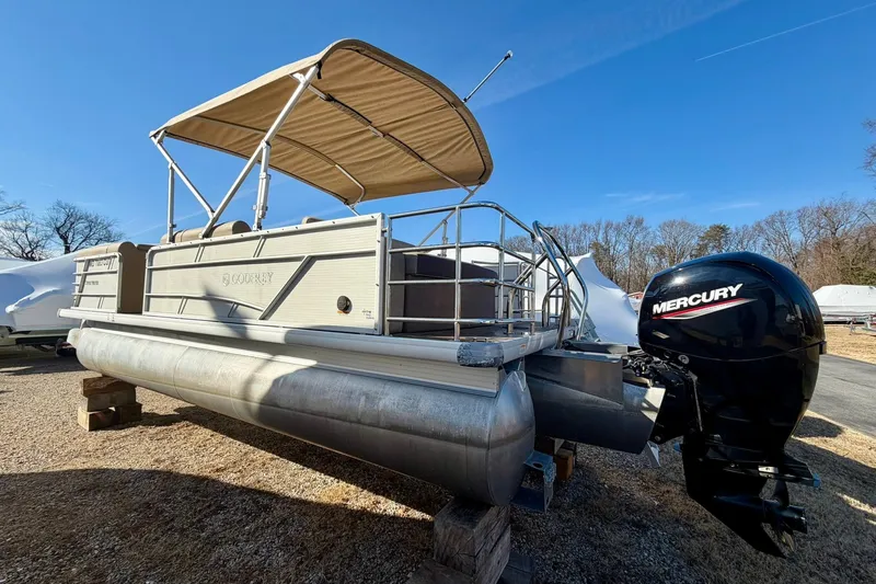 Slide: The Image of 2023 Godfrey Sweetwater 2286 SFL pontoon boat with Mercury outboard motor, parked outdoors. - 2