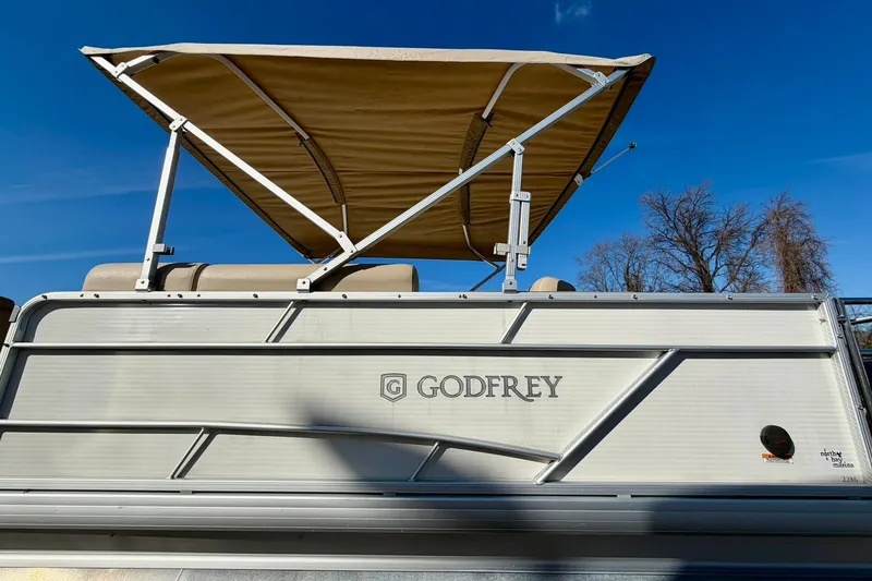 Slide: The Image of 2023 Godfrey Sweetwater 2286 SFL pontoon boat with canopy under clear blue sky. - 8