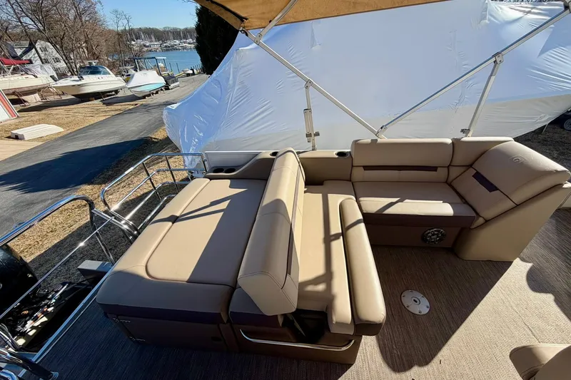 Slide: The Image of 2023 Godfrey Sweetwater 2286 SFL pontoon boat with beige seating and canopy, docked near water. - 9
