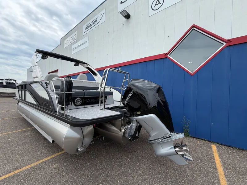 Slide: The Image of 2026 Harris Grand Mariner 230 boat parked by a blue building. - 5