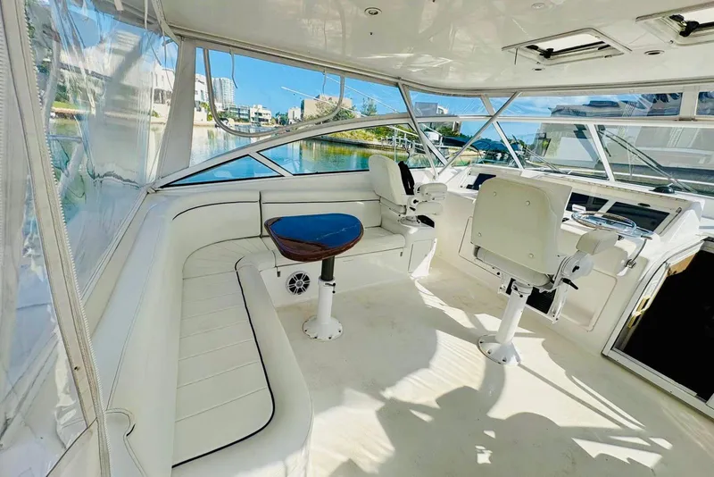 Slide: The Image of 2004 Viking 45 Convertible yacht interior with white seating and helm, overlooking water. - 3