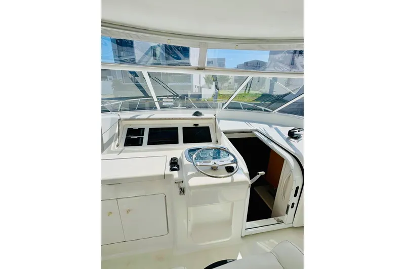 Slide: The Image of 2004 Viking 45 Convertible yacht helm with steering wheel and navigation controls. - 6