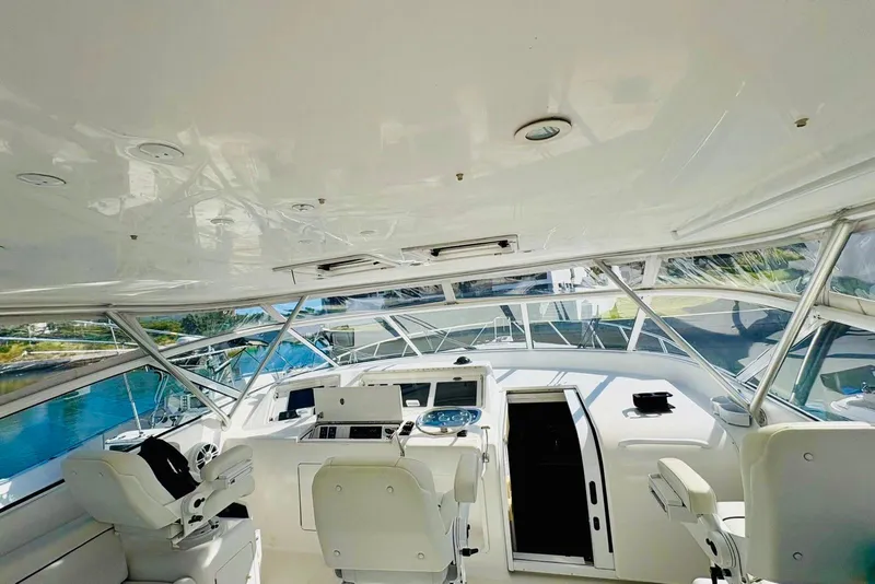 Slide: The Image of Interior view of 2004 Viking 45 Convertible yacht cockpit with white seating and control panel. - 5
