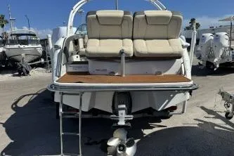 Slide: The Image of 2019 Bryant Calandra 23 boat, rear view with seating and motor, parked outdoors. - 4