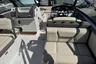 Slide: The Image of 2019 Bryant Calandra 23 boat interior with beige seating and modern dashboard. - 6