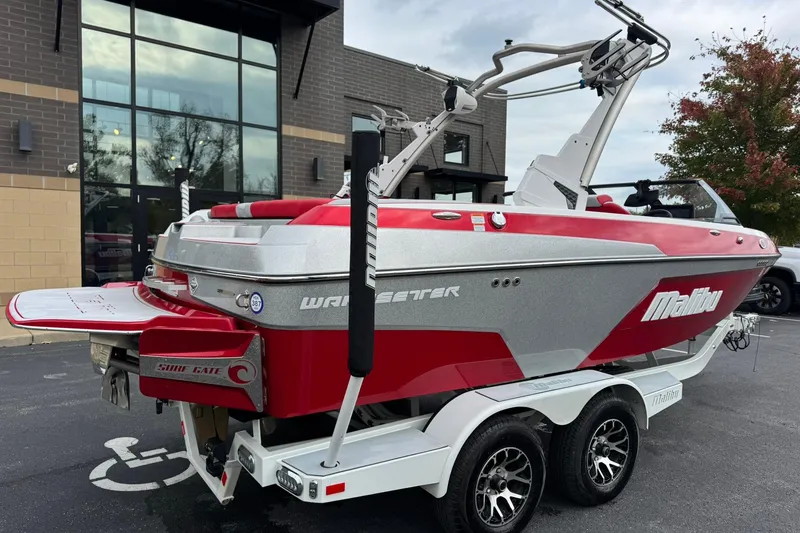 Slide: The Image of 2023 Malibu Wakesetter 20 VTX boat in red and silver on a trailer. - 3