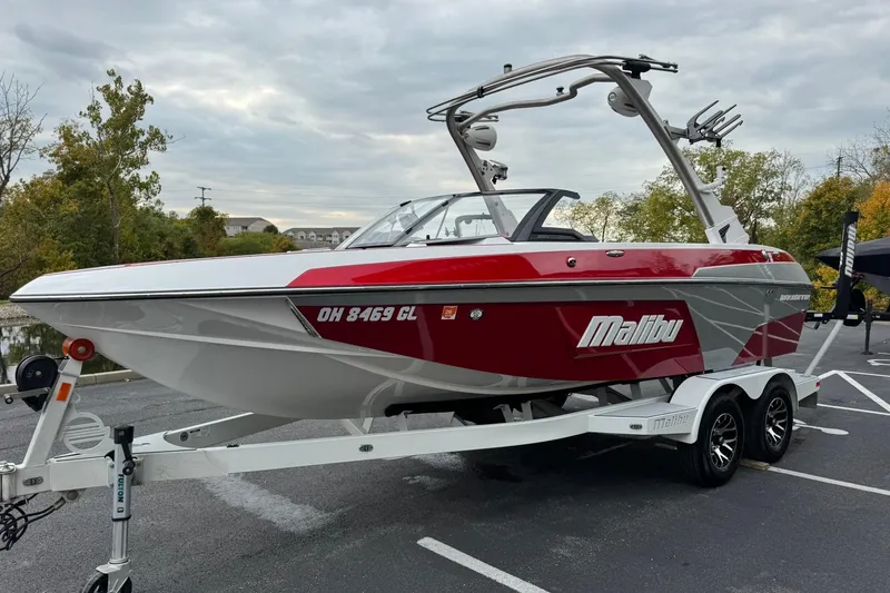 Slide: The Image of 2023 Malibu Wakesetter 20 VTX boat on trailer, red and white design, parked outdoors. - 7