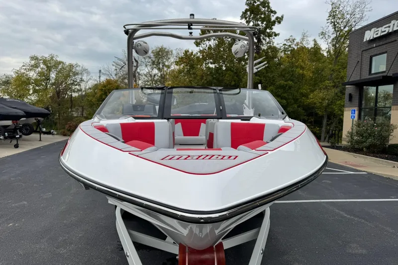 Slide: The Image of 2023 Malibu Wakesetter 20 VTX boat with red and white interior, parked outdoors. - 8