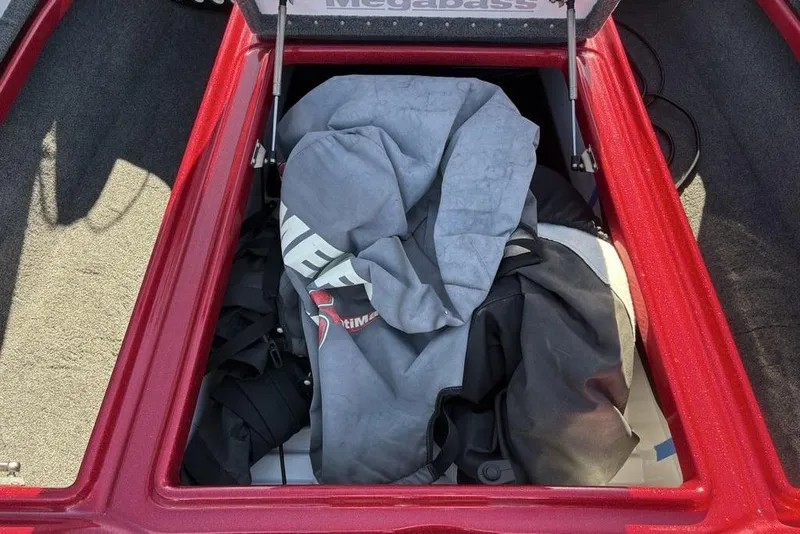 Slide: The Image of Open storage compartment in 2017 Phoenix 919 ProXP boat, featuring carpeted interior and rod holders. - 13