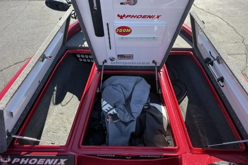 Slide: The Image of Open storage compartment in a 2017 Phoenix 919 ProXP boat, featuring red interior. - 17