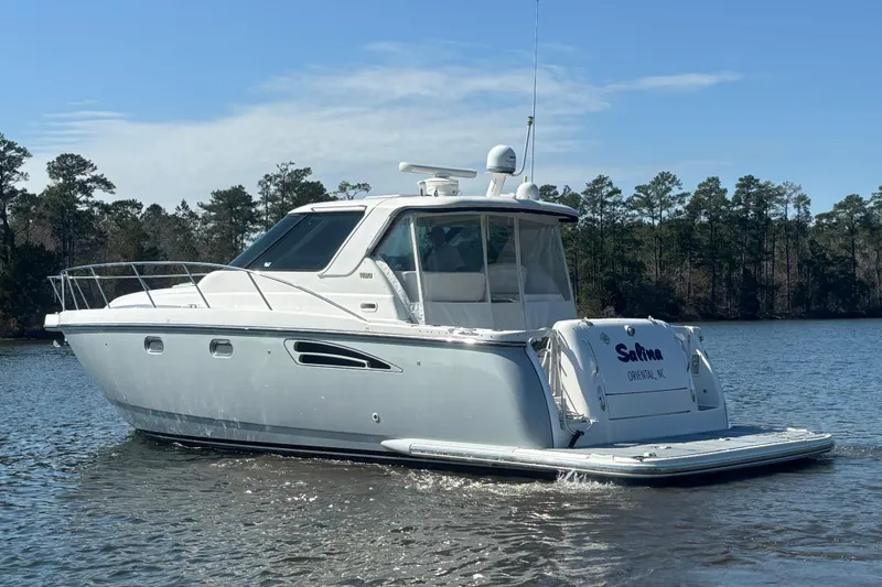 Slide: The Image of 2004 Tiara Yachts 3600 Sovran cruising on a serene lake with forested background. - 2