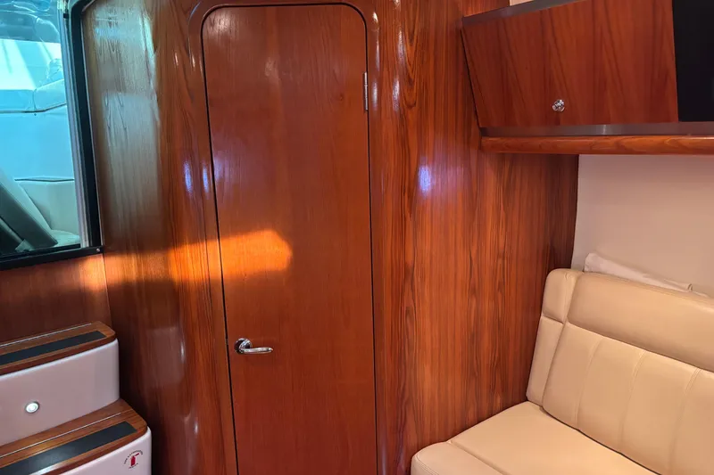 Slide: The Image of 2004 Tiara Yachts 3600 Sovran interior with wood paneling and beige seating. - 28