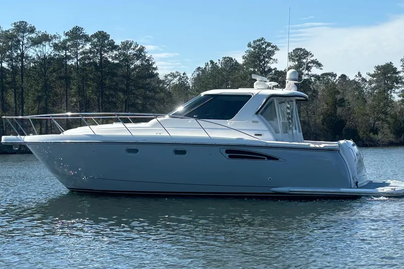 Slide: The Image of 2004 Tiara Yachts 3600 Sovran cruising on a serene lake with forested background. - 3