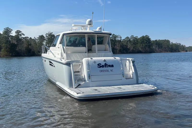 Slide: The Image of 2004 Tiara Yachts 3600 Sovran on calm water, rear view with trees in background. - 5