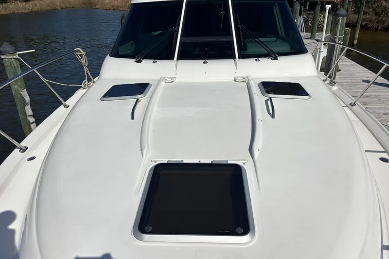 Slide: The Image of 2004 Tiara Yachts 3600 Sovran deck with hatches and railing, docked by water. - 9