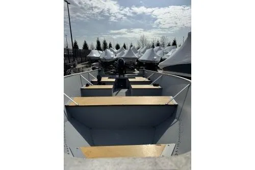 Slide: The Image of 2023 Lund SSV-14 Tiller boat with wooden seats, parked outdoors under cloudy sky. - 14