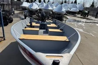 Slide: The Image of 2023 Lund SSV-14 Tiller boat displayed outdoors with other covered boats. - 8