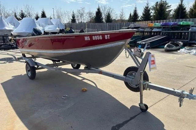Slide: The Image of 2023 Lund SSV-14 Tiller boat on trailer, red and silver, parked outdoors. - 9