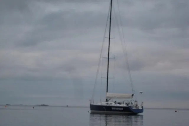 Slide: The Image of Sailboat on calm water under cloudy sky, Tripp 47 model, 1995. - 12