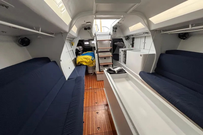 Slide: The Image of Interior of a 1995 Tripp 47 sailboat with blue seating and wooden flooring. - 24