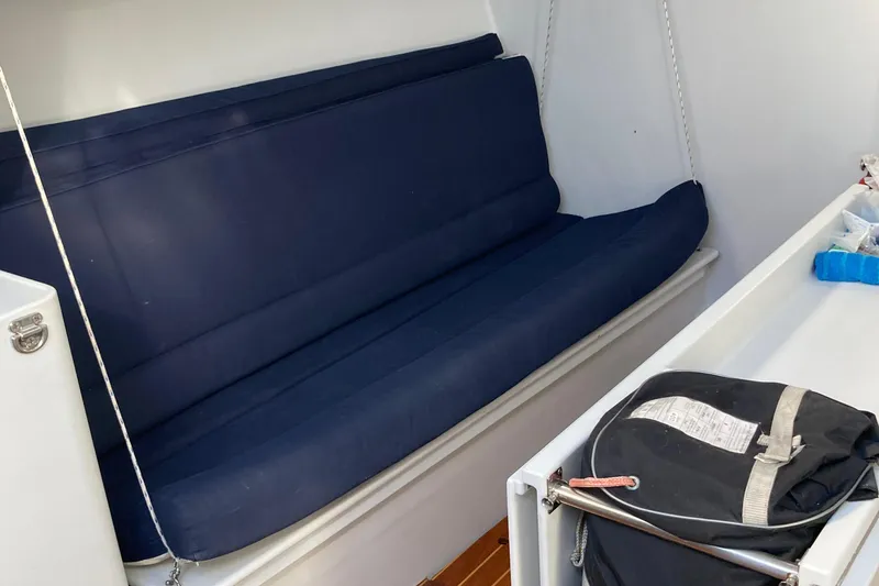 Slide: The Image of Interior of a 1995 Tripp 47 sailboat with blue cushioned seating. - 25