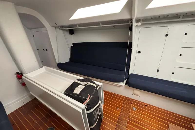 Slide: The Image of Interior of a 1995 Tripp 47 sailboat with blue seating and wooden flooring. - 29