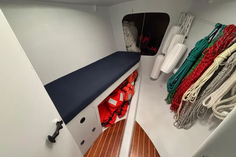 Slide: The Image of Interior of a 1995 Tripp 47 sailboat with ropes, life jackets, and storage. - 39