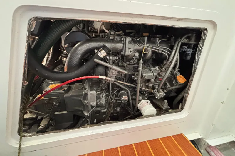 Slide: The Image of Engine compartment of a 1995 Tripp 47 sailboat, showcasing mechanical components and hoses. - 55