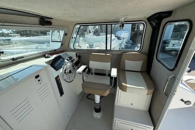 Slide: The Image of 2019 Parker 2520 XLD Sport Cabin interior with helm and seating area. - 12