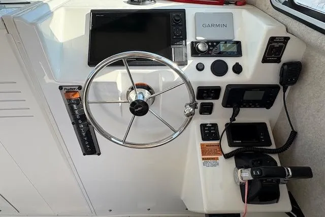 Slide: The Image of 2019 Parker 2520 XLD Sport Cabin helm with Garmin navigation system and steering wheel. - 13