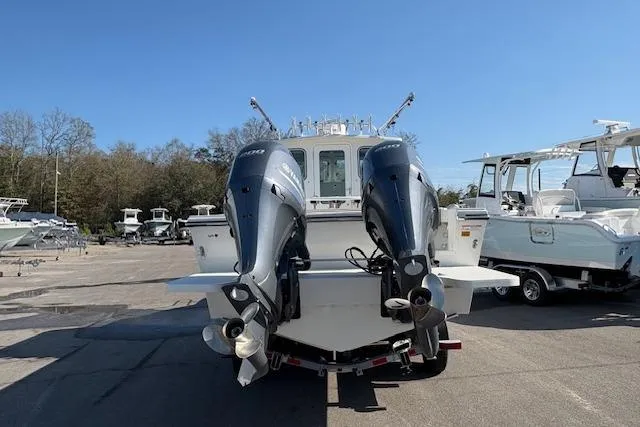 Slide: The Image of 2019 Parker 2520 XLD Sport Cabin boat with dual outboard motors in a marina. - 2