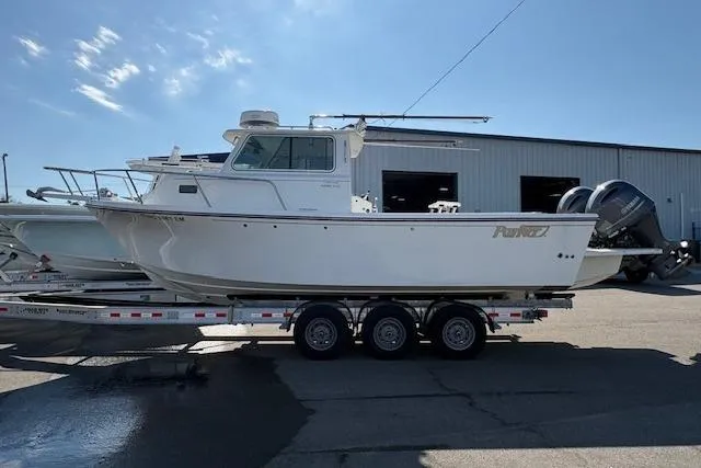 Slide: The Image of 2019 Parker 2520 XLD Sport Cabin boat on a trailer, parked outside a warehouse. - 3