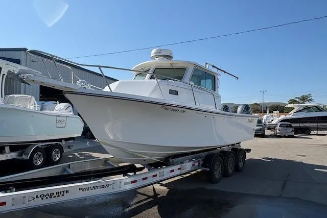Slide: The Image of 2019 Parker 2520 XLD Sport Cabin boat on trailer in marina setting. - 4
