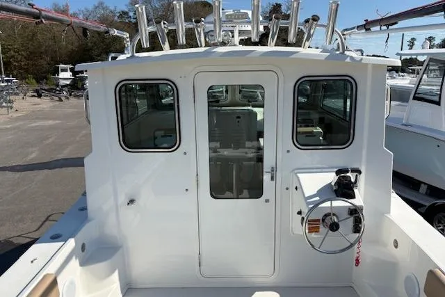 Slide: The Image of 2019 Parker 2520 XLD Sport Cabin boat with white exterior and fishing rod holders. - 8