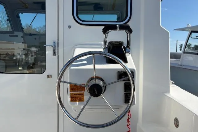 Slide: The Image of 2019 Parker 2520 XLD Sport Cabin boat helm with steering wheel and controls. - 9