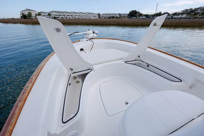 Slide: The Image of 2017 Chaos 21 Tarpon Bay boat interior with open storage compartments on calm water. - 10