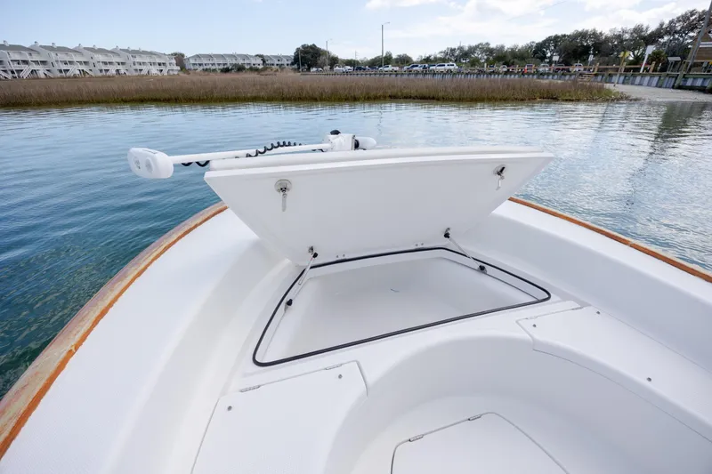 Slide: The Image of 2017 Chaos 21 Tarpon Bay boat with open storage compartment on calm water. - 12