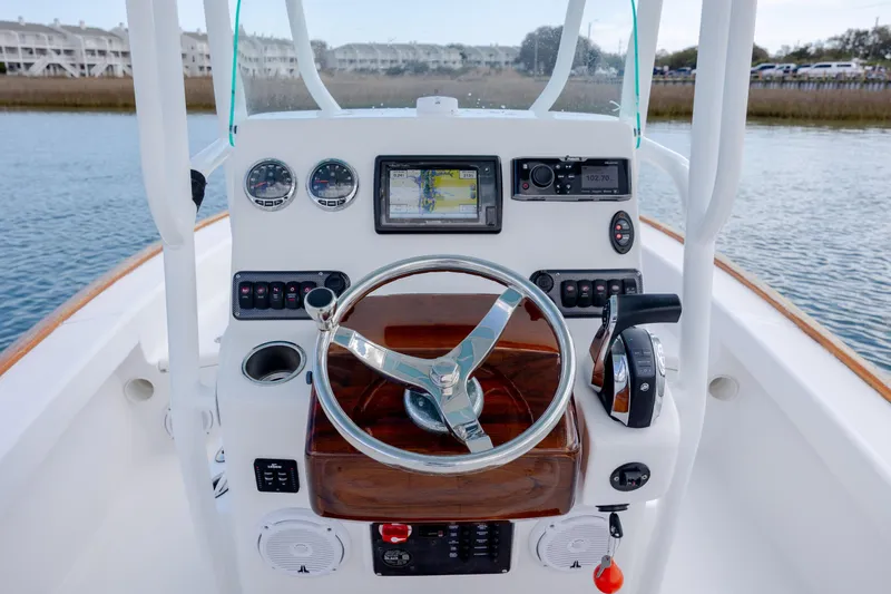 Slide: The Image of 2017 Chaos 21 Tarpon Bay boat dashboard with steering wheel and navigation instruments. - 22