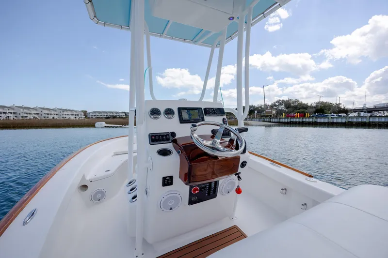 Slide: The Image of 2017 Chaos 21 Tarpon Bay boat interior with steering console, on calm water. - 23
