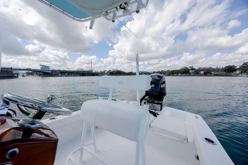 Slide: The Image of 2017 Chaos 21 Tarpon Bay boat on water, featuring steering wheel and outboard motor. - 24