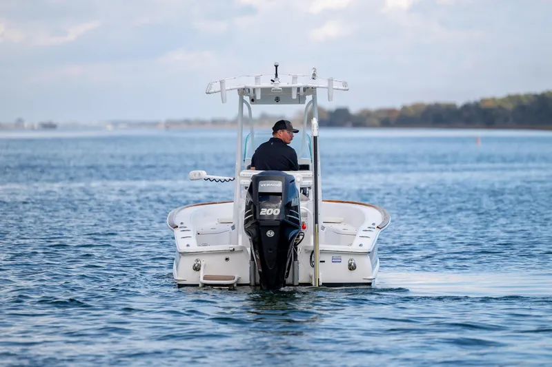 Slide: The Image of 2017 Chaos 21 Tarpon Bay boat on calm water, rear view with outboard motor. - 7