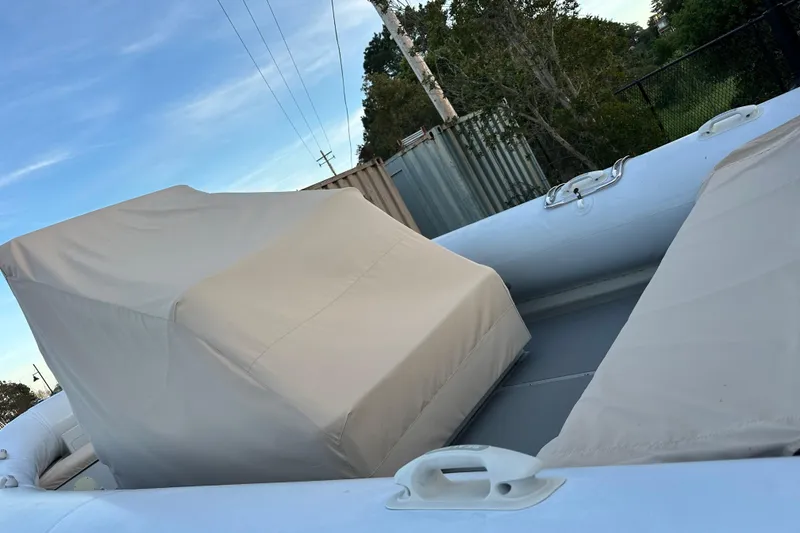 Slide: The Image of 2020 Sealegs 9m Amphibious RIB with protective covers, parked outdoors. - 11